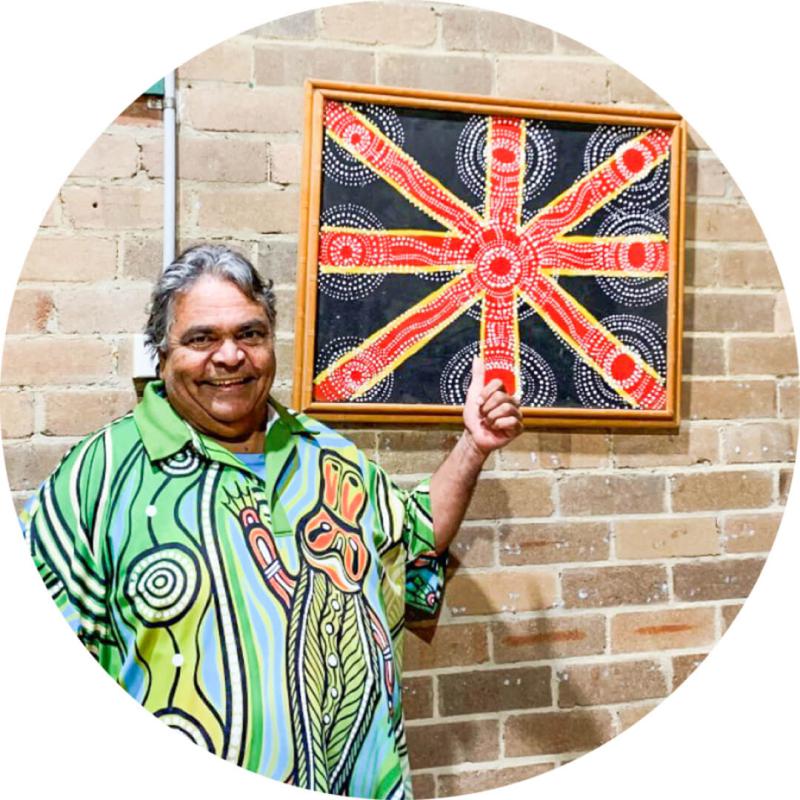 A woman showing Aboriginal artwork with a smile